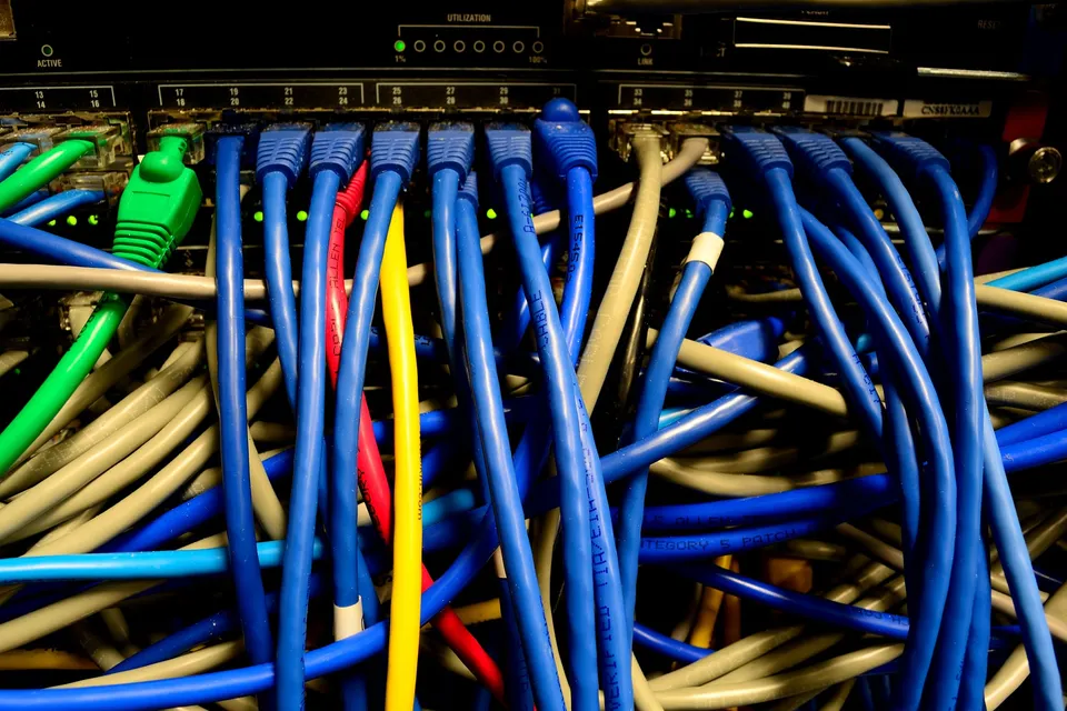 Blue, green and yellow network cables plugged into a switch
