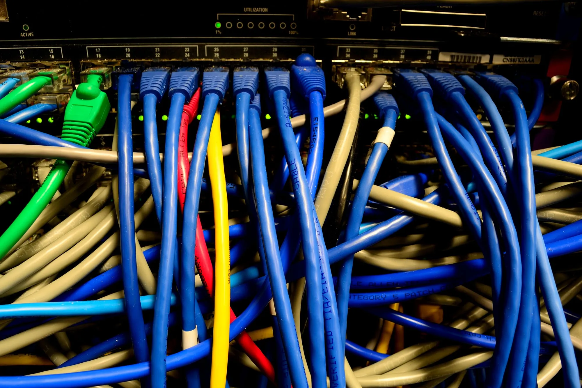 Blue, green and yellow network cables plugged into a switch